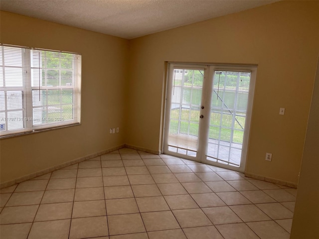 17691 SW 4th Ct, Pembroke Pines, FL 33029 - empty room with plenty of natural light, light tile patterned floors, a textured ceiling, baseboards, and vaulted ceiling