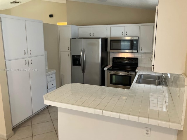 17691 SW 4th Ct, Pembroke Pines, FL 33029 - kitchen featuring stainless steel appliances, a sink, lofted ceiling, tasteful backsplash, and a peninsula