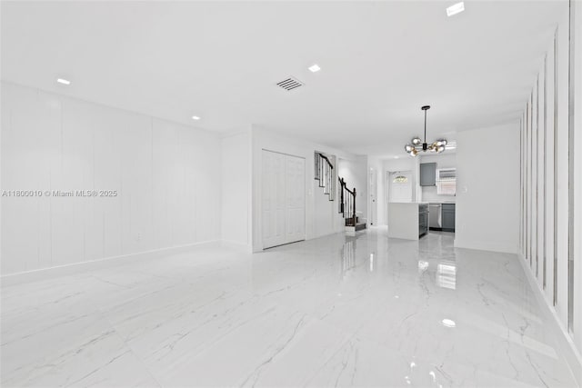 450 SE 7th St Unit 214, Dania Beach, FL 33004 - empty room featuring a chandelier, stairs, light marble finish flooring, and baseboards