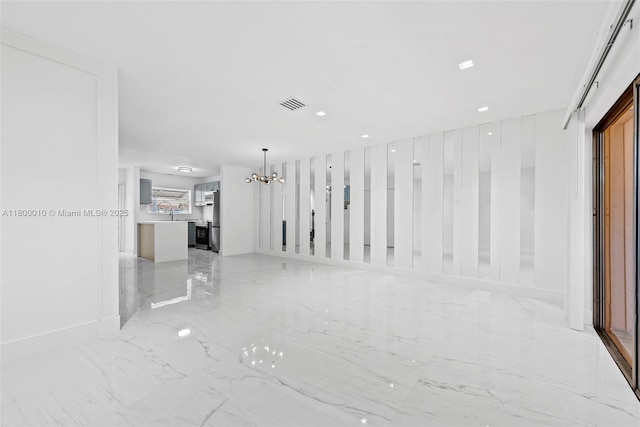 450 SE 7th St Unit 214, Dania Beach, FL 33004 - unfurnished living room with light marble finish floors, a chandelier, and baseboards