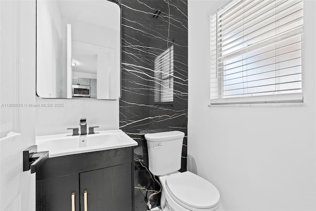 450 SE 7th St Unit 214, Dania Beach, FL 33004 - half bath featuring toilet, vanity, and tile walls
