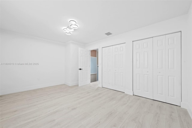 450 SE 7th St Unit 214, Dania Beach, FL 33004 - unfurnished bedroom with multiple closets, wood finished floors, and baseboards