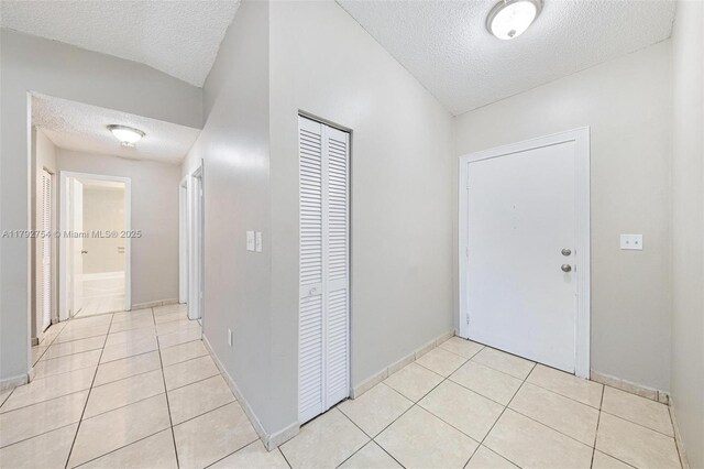 19231 SW 121st Ave, Miami, FL 33177 - hallway featuring a textured ceiling, light tile patterned floors, and baseboards