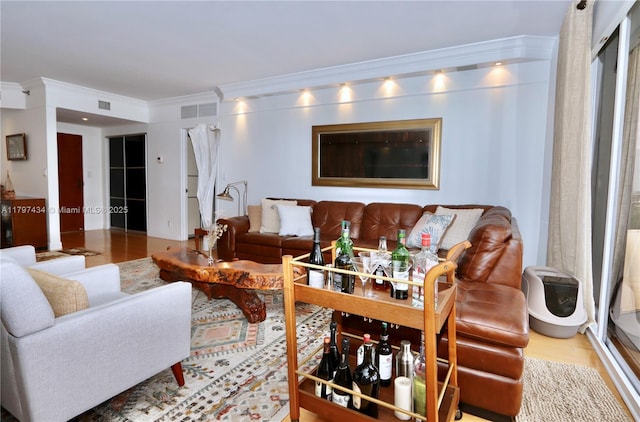 living room featuring ornamental molding and wood finished floors