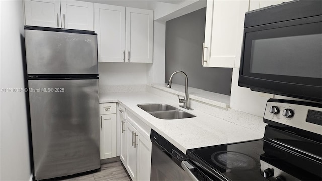 1720 NW N River Dr Unit 113, Miami, FL 33125 - kitchen featuring stainless steel appliances, a sink, white cabinets, light countertops, and light wood-style floors