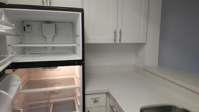 1720 NW N River Dr Unit 113, Miami, FL 33125 - kitchen featuring white cabinetry and light stone countertops