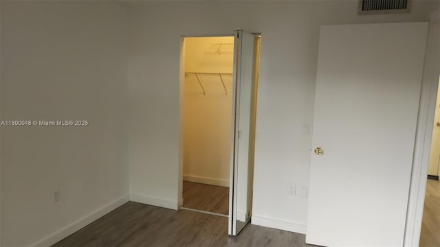 1720 NW N River Dr Unit 113, Miami, FL 33125 - unfurnished bedroom featuring wood finished floors, a closet, baseboards, and a spacious closet