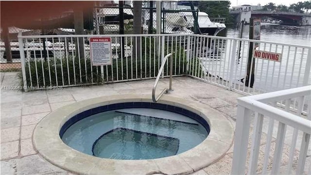 1720 NW N River Dr Unit 113, Miami, FL 33125 - view of pool featuring a community hot tub, a water view, and fence