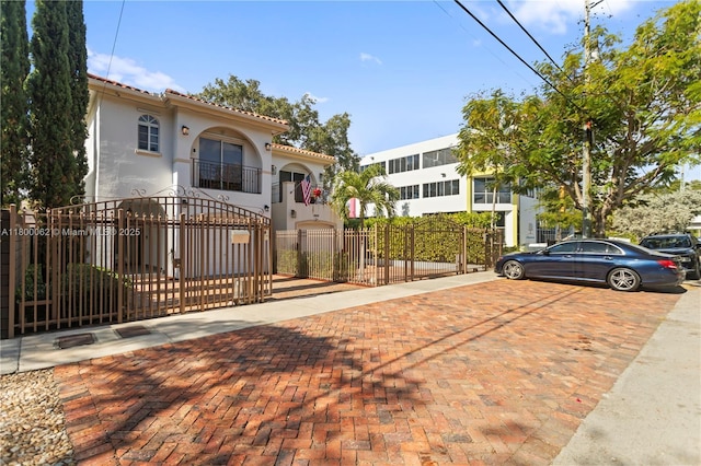 2924 Bridgeport Ave, Miami, FL 33133 - view of front of home featuring a fenced front yard, stucco siding, a gate, and a tile roof