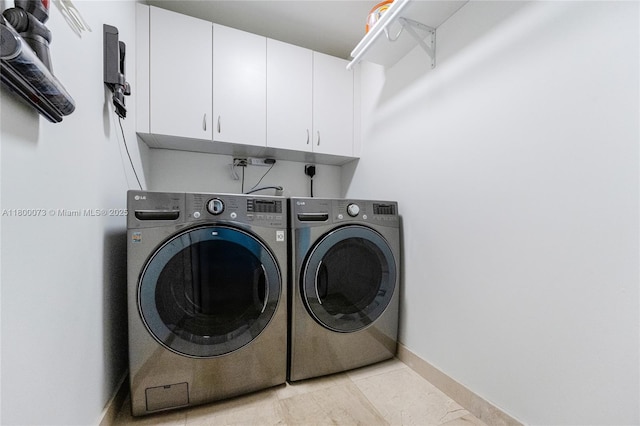 washroom featuring washer and dryer, cabinet space, baseboards, and light tile patterned floors