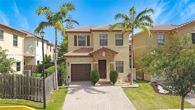 8897 SW 229th St, Cutler Bay, FL 33190 - mediterranean / spanish house with a tile roof, stucco siding, fence, decorative driveway, and an attached garage