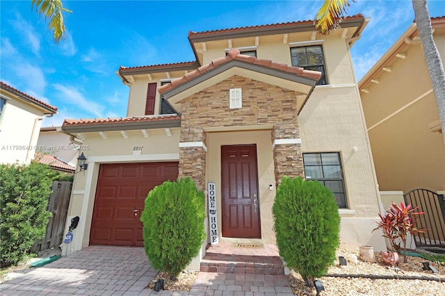 8897 SW 229th St, Cutler Bay, FL 33190 - mediterranean / spanish home featuring stucco siding, stone siding, a garage, a tiled roof, and driveway