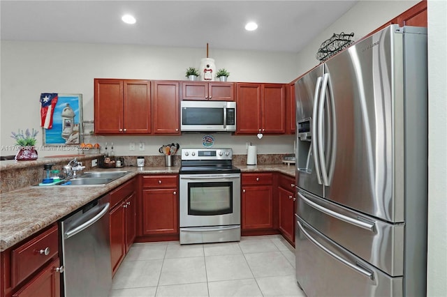 8897 SW 229th St, Cutler Bay, FL 33190 - kitchen featuring appliances with stainless steel finishes, a sink, light tile patterned flooring, reddish brown cabinets, and recessed lighting