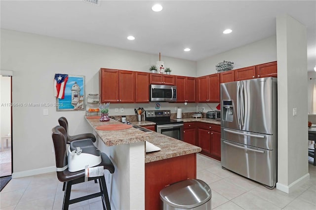 8897 SW 229th St, Cutler Bay, FL 33190 - kitchen with stainless steel appliances, a peninsula, a breakfast bar area, light countertops, and recessed lighting