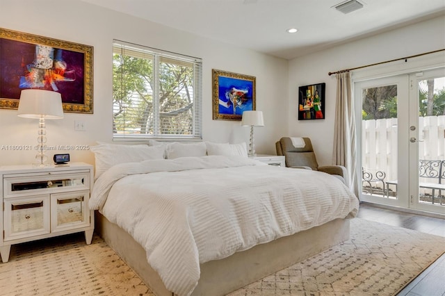 bedroom with access to outside, multiple windows, french doors, light wood-type flooring, and recessed lighting