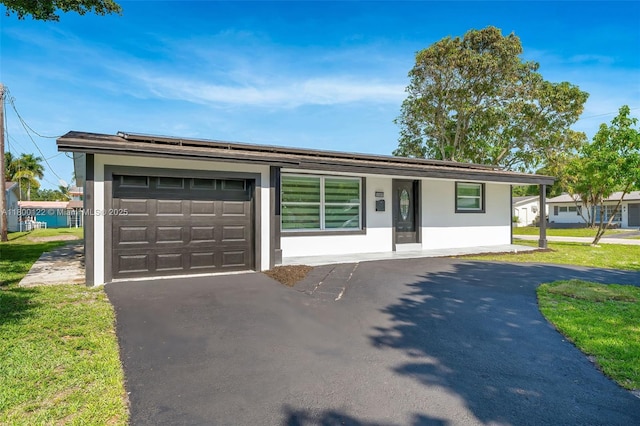 view of front of home featuring driveway, an attached garage, and stucco siding