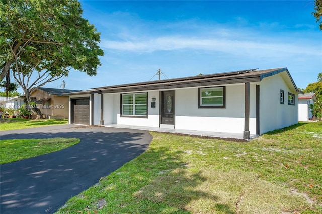 ranch-style house featuring an attached garage, asphalt driveway, and stucco siding