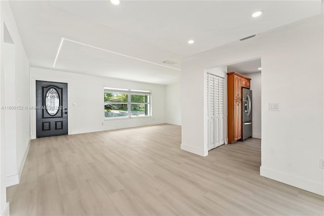unfurnished living room featuring baseboards, light wood finished floors, and recessed lighting