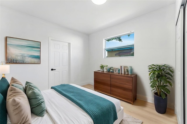 bedroom with light wood-type flooring and baseboards