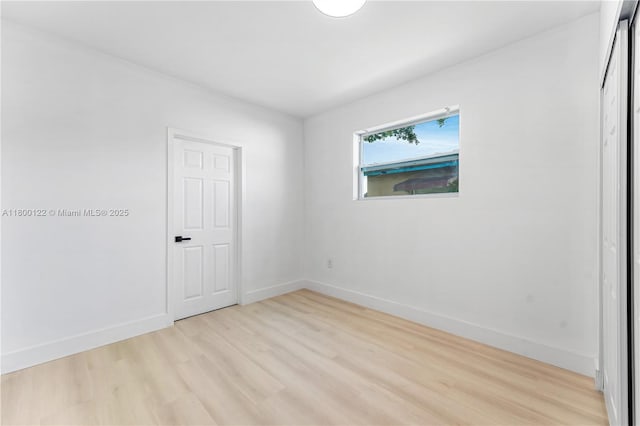 unfurnished room with light wood finished floors and baseboards