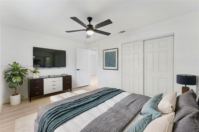 bedroom featuring a closet, light wood-style flooring, and a ceiling fan