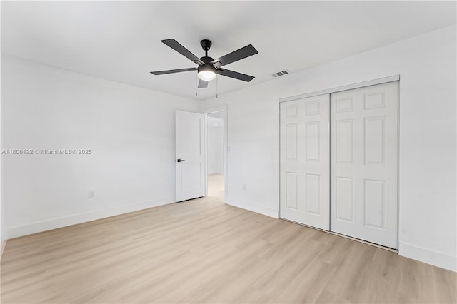 unfurnished bedroom with light wood-type flooring, baseboards, a closet, and ceiling fan