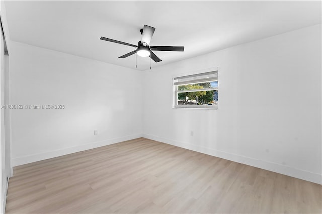 empty room featuring light wood-style floors, baseboards, and a ceiling fan