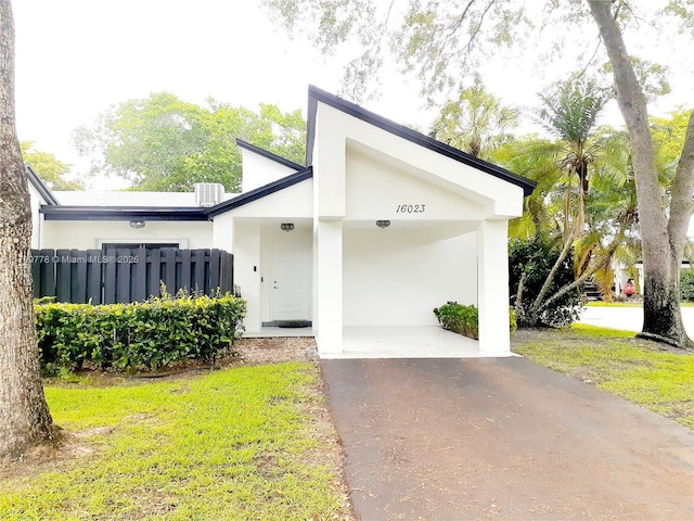 16023 S Fairway Ter Unit 118, Weston, FL 33326 - view of front of home with asphalt driveway, a carport, stucco siding, and central AC