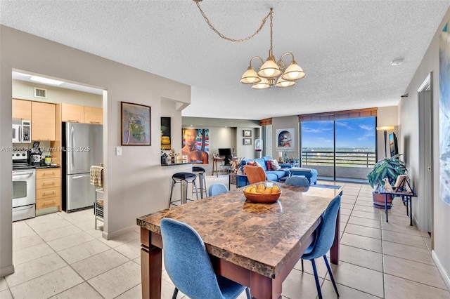 3300 NE 191st St Unit Lp04, Aventura, FL 33180 - dining space with a chandelier, a textured ceiling, light tile patterned flooring, and baseboards
