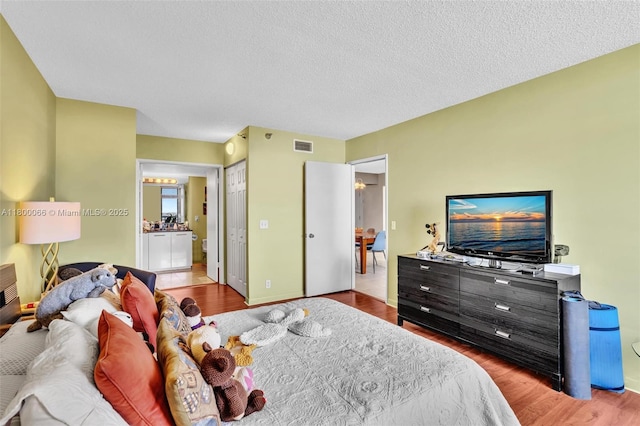 3300 NE 191st St Unit Lp04, Aventura, FL 33180 - bedroom with wood finished floors, a textured ceiling, baseboards, and ensuite bath
