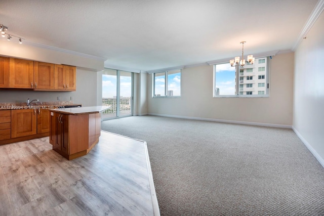 1745 E Hallandale Beach Blvd Unit 1903W, Hallandale Beach, FL 33009 - kitchen with crown molding, brown cabinets, a chandelier, a kitchen island, and baseboards