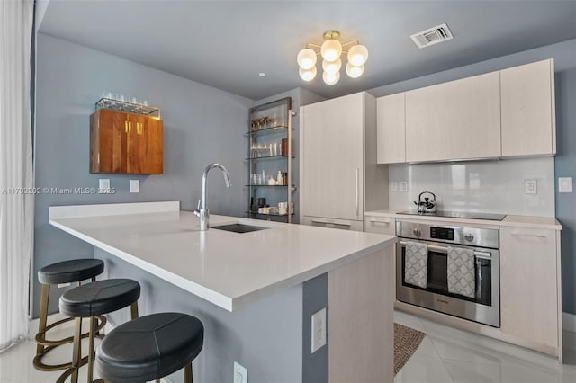 501 NE 31st St Unit 2906, Miami, FL 33137 - kitchen featuring oven, a sink, a breakfast bar area, and light countertops