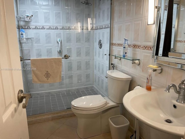8360 Sands Point Blvd Unit G209, Tamarac, FL 33321 - bathroom featuring a sink, a stall shower, toilet, tile patterned floors, and tile walls