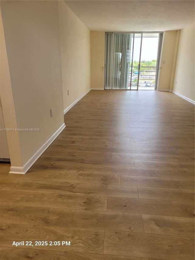 14140 SW 84th St Unit 301-H, Miami, FL 33183 - spare room featuring wood finished floors, baseboards, and expansive windows