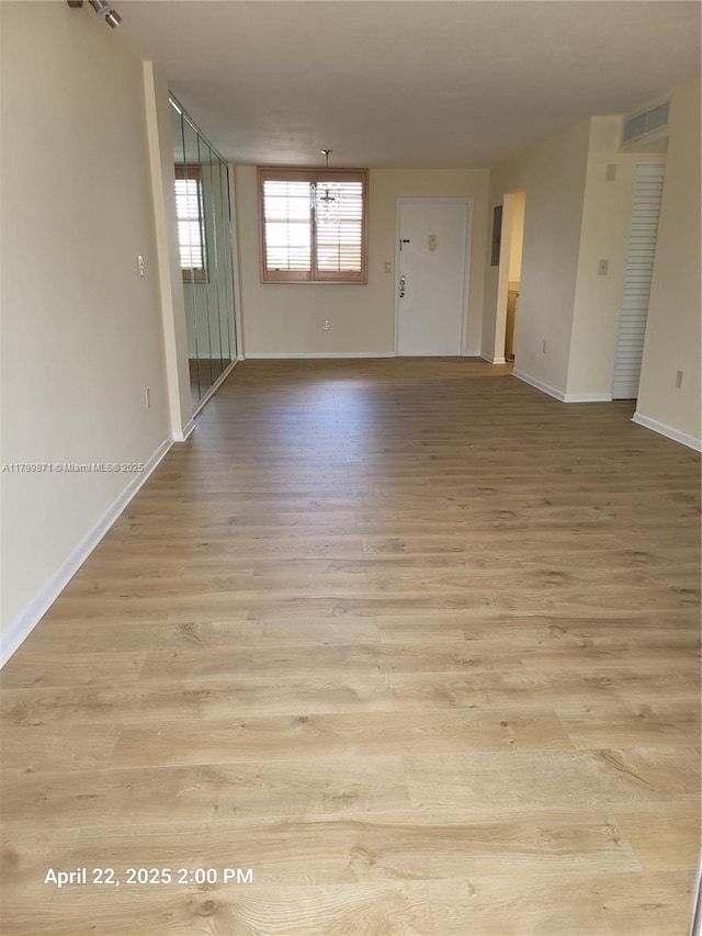 14140 SW 84th St Unit 301-H, Miami, FL 33183 - spare room featuring light wood-type flooring, baseboards, and a chandelier