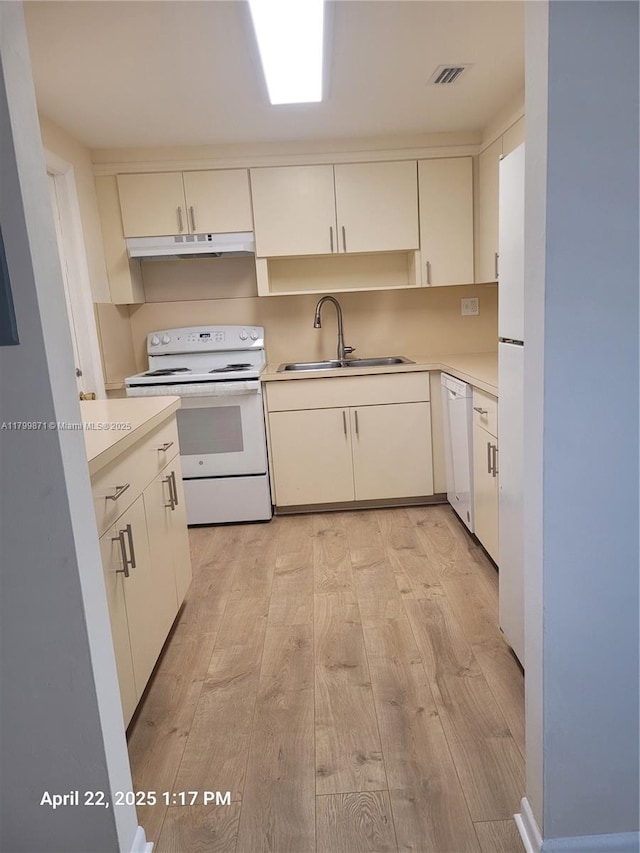 14140 SW 84th St Unit 301-H, Miami, FL 33183 - kitchen featuring white appliances, a sink, under cabinet range hood, light countertops, and light wood-style floors