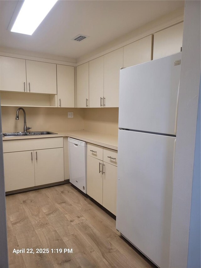 14140 SW 84th St Unit 301-H, Miami, FL 33183 - kitchen with white appliances, a sink, light wood-style flooring, and white cabinetry