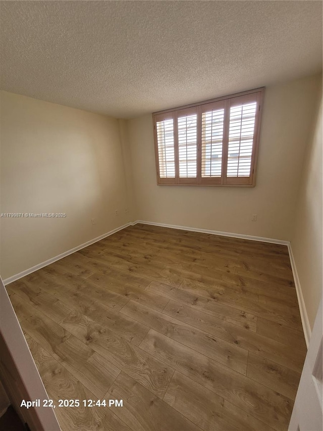 14140 SW 84th St Unit 301-H, Miami, FL 33183 - empty room with a textured ceiling, wood finished floors, and baseboards