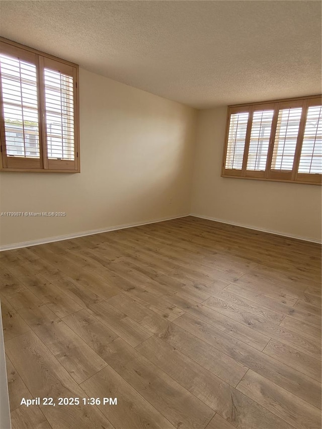 14140 SW 84th St Unit 301-H, Miami, FL 33183 - spare room with a textured ceiling, hardwood / wood-style floors, healthy amount of natural light, and baseboards