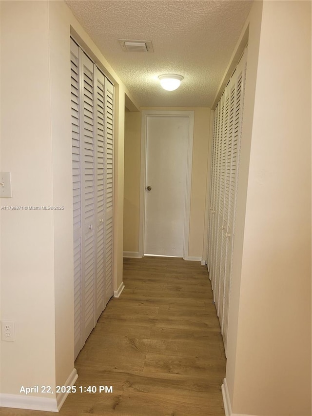 14140 SW 84th St Unit 301-H, Miami, FL 33183 - hallway featuring wood finished floors and a textured ceiling