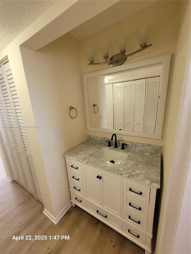 14140 SW 84th St Unit 301-H, Miami, FL 33183 - bathroom with wood finished floors, baseboards, vanity, and a closet