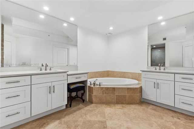 bathroom featuring a shower stall, a bath, two vanities, and recessed lighting