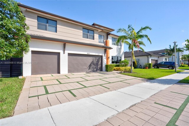 9015 NW 161st Ter, Miami Lakes, FL 33018 - view of front of home featuring a garage, driveway, a front lawn, and stucco siding
