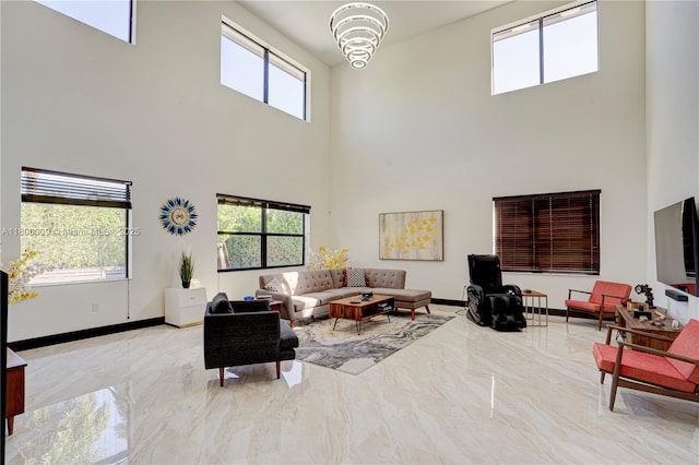 9015 NW 161st Ter, Miami Lakes, FL 33018 - living room with a towering ceiling, a chandelier, marble finish floors, and baseboards