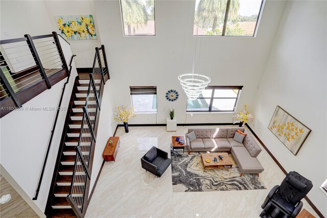 9015 NW 161st Ter, Miami Lakes, FL 33018 - living room with a towering ceiling, stairs, and a chandelier