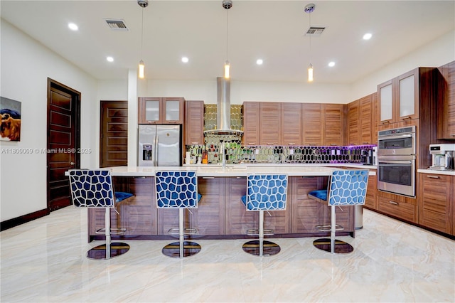 9015 NW 161st Ter, Miami Lakes, FL 33018 - kitchen with stainless steel appliances, wall chimney range hood, light countertops, a kitchen breakfast bar, and recessed lighting