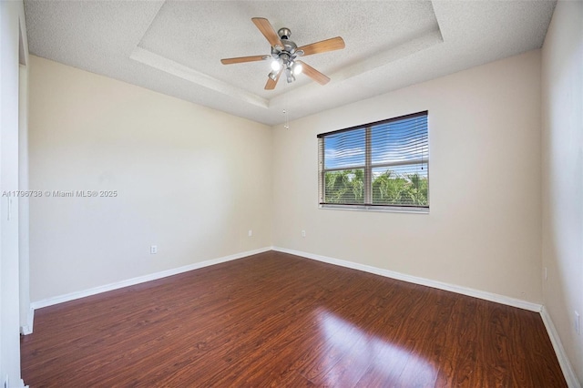 2252 NE 42nd Cir, Homestead, FL 33033 - unfurnished room with a tray ceiling, dark wood-style floors, baseboards, a textured ceiling, and a ceiling fan