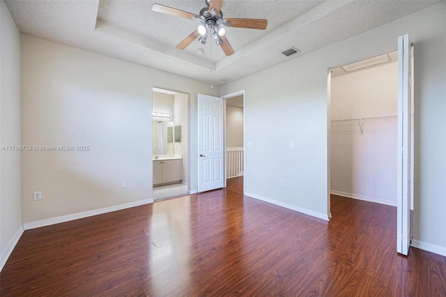 2252 NE 42nd Cir, Homestead, FL 33033 - unfurnished bedroom with wood finished floors, a textured ceiling, a walk in closet, a closet, and baseboards