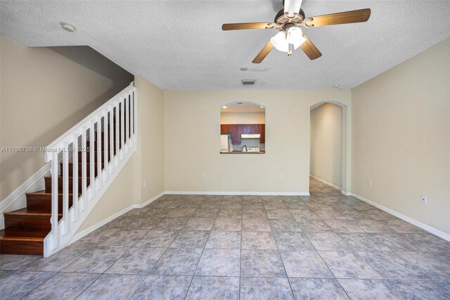 2252 NE 42nd Cir, Homestead, FL 33033 - unfurnished living room featuring a textured ceiling, a ceiling fan, stairs, baseboards, and a sink