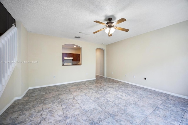 2252 NE 42nd Cir, Homestead, FL 33033 - empty room featuring a ceiling fan, a textured ceiling, arched walkways, and baseboards